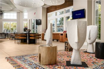 A modern art installation featuring two large white sculptures in a spacious lobby.